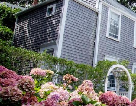 flowers in front of nantucket vacation rental with quintessential shingles 