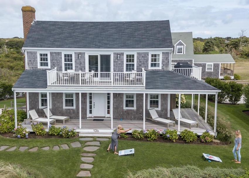 two people playing corn hole bags game on the lawn at a nantucket vacation rental home