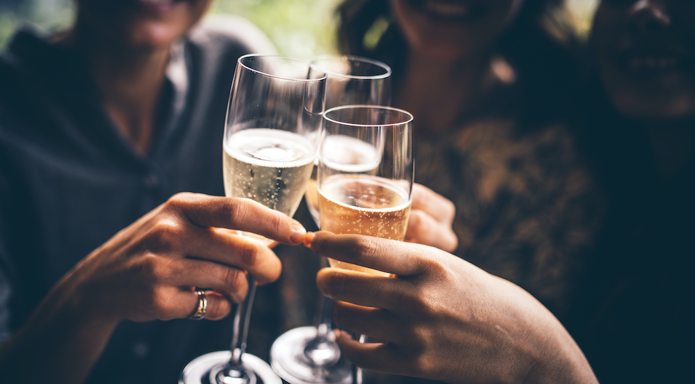 three friends cheers with champagne glasses