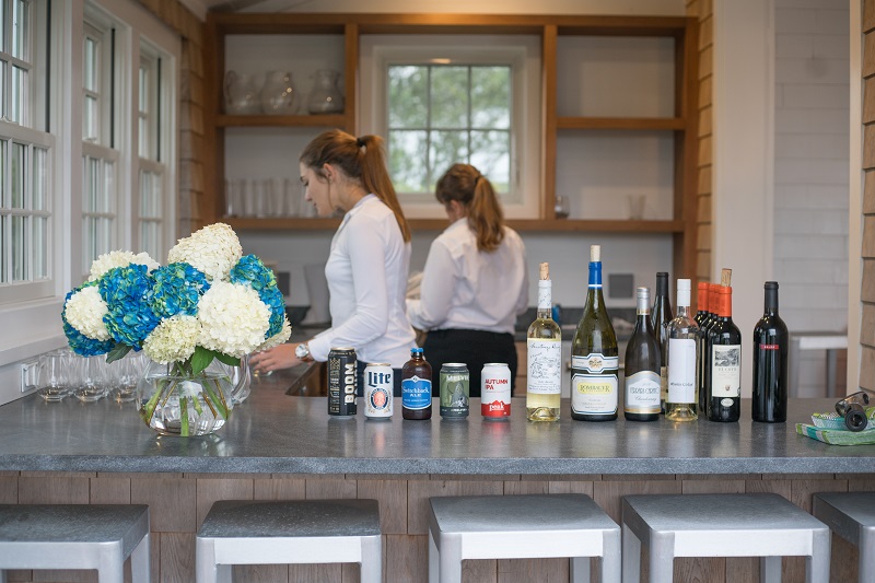 two girl staff members behind a bar in a kitchen at a nantucket vacation rental